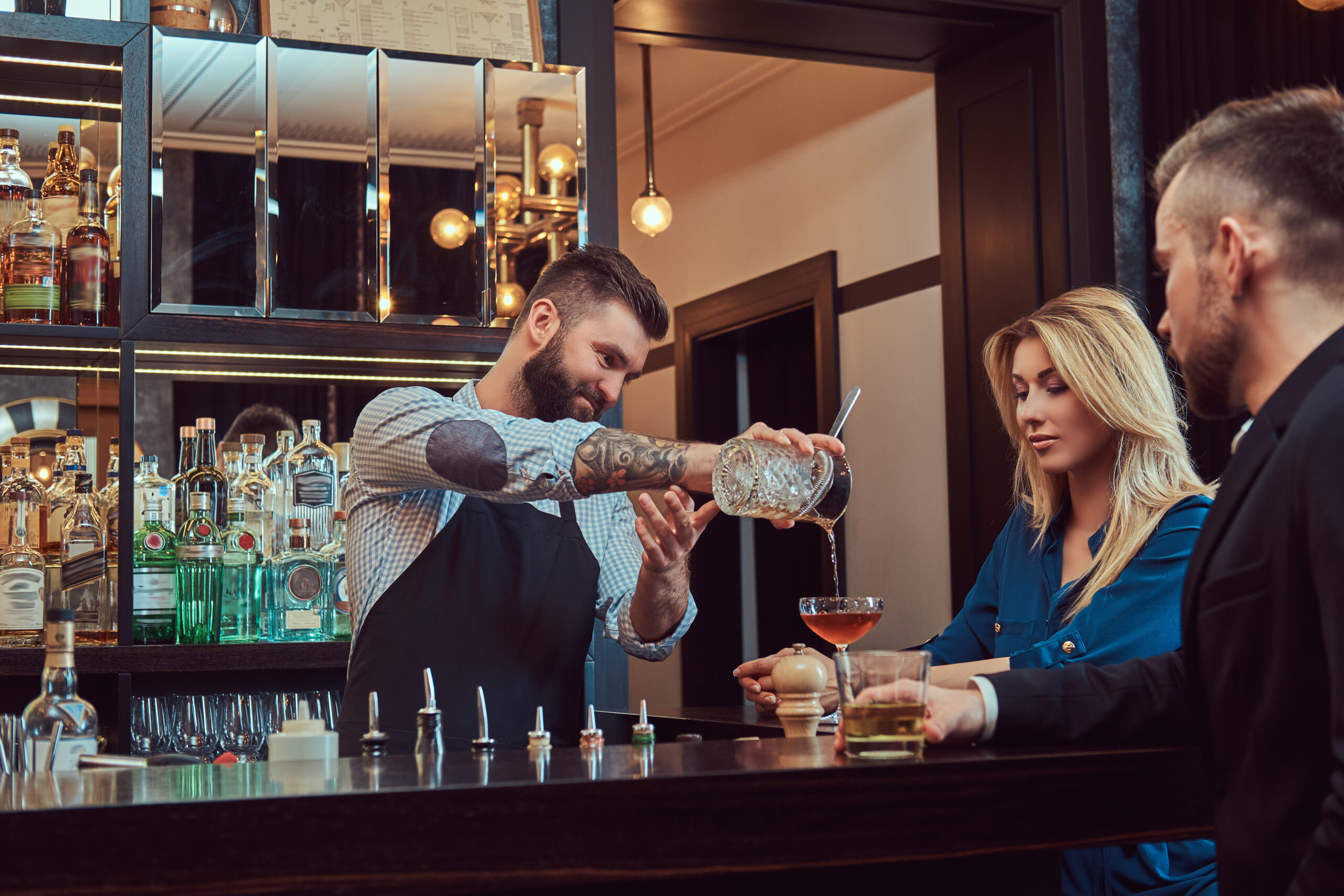 Stylish brutal barman serves an attractive couple who spend an evening on a date.